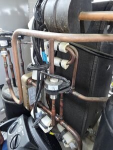 Koelinstallatie met koperleidingen en koelmiddelcomponenten in horeca koelsysteem